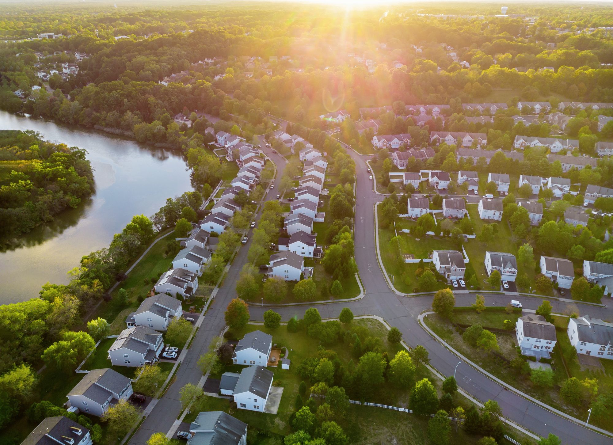 Aerial view of a riverside neighborhood at sunrise